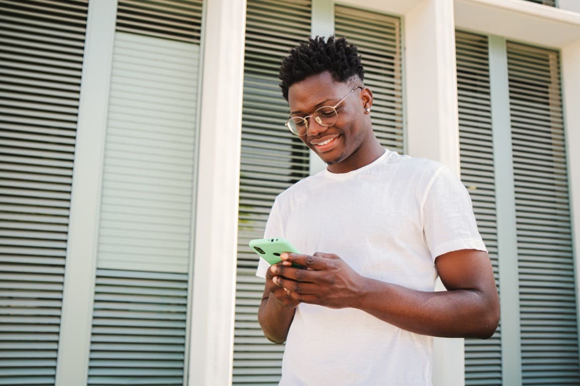 Man paying bills on his phone outdoors during the day
