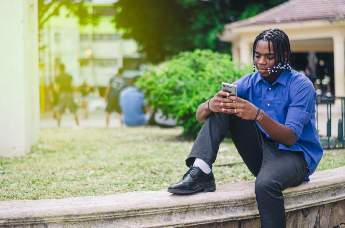 Young man with curly hair using his phone
