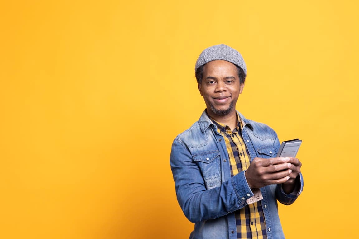 Man smiling while using his mobile phone